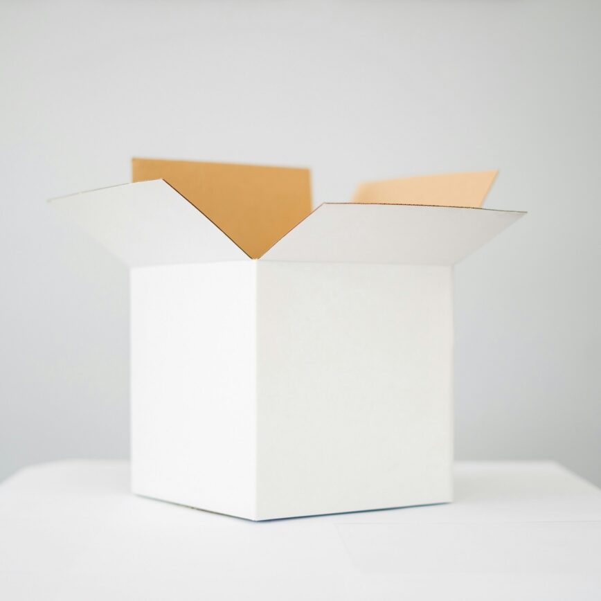 a white cardboard box on top of a white table with a white background.