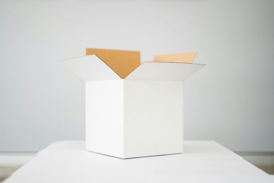 a white cardboard box on top of a white table with a white background.