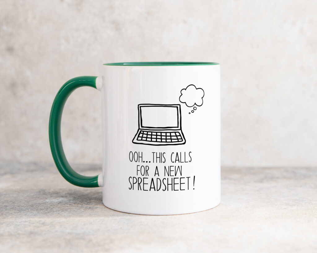 a white ceramic mug showing the text 'ooh... this calls for a new spreadsheet' below an illustration of an open laptop.