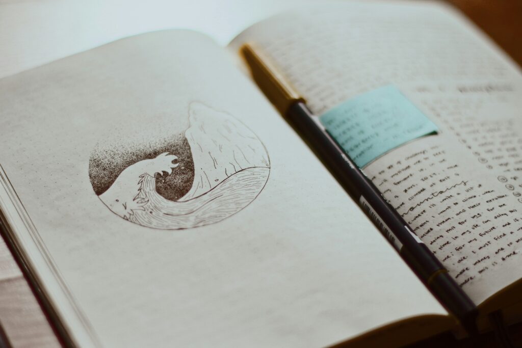 showcasing the inside of an artistic journal, showing a brief drawing/sketch and handwriting text.